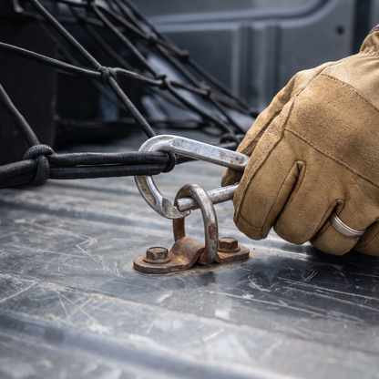 Metal carabiner clipped to a truck bed tie-down