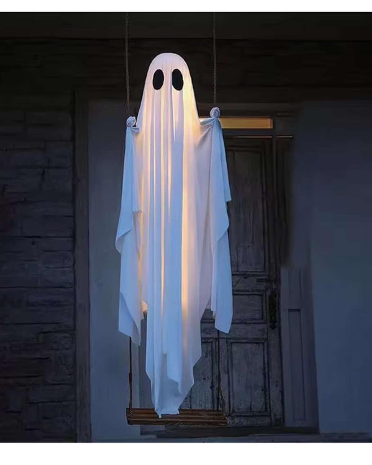 The swing ghost glowing warm white on a porch after dark