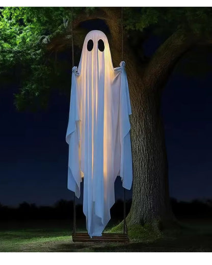 The swing ghost hanging from a tree branch at night