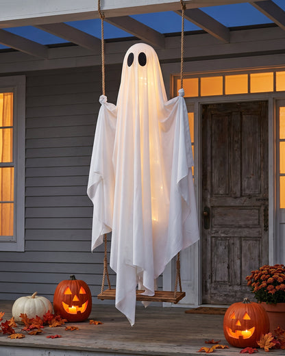 Wider view of the porch with the swing ghost, pumpkins and fallen leaves