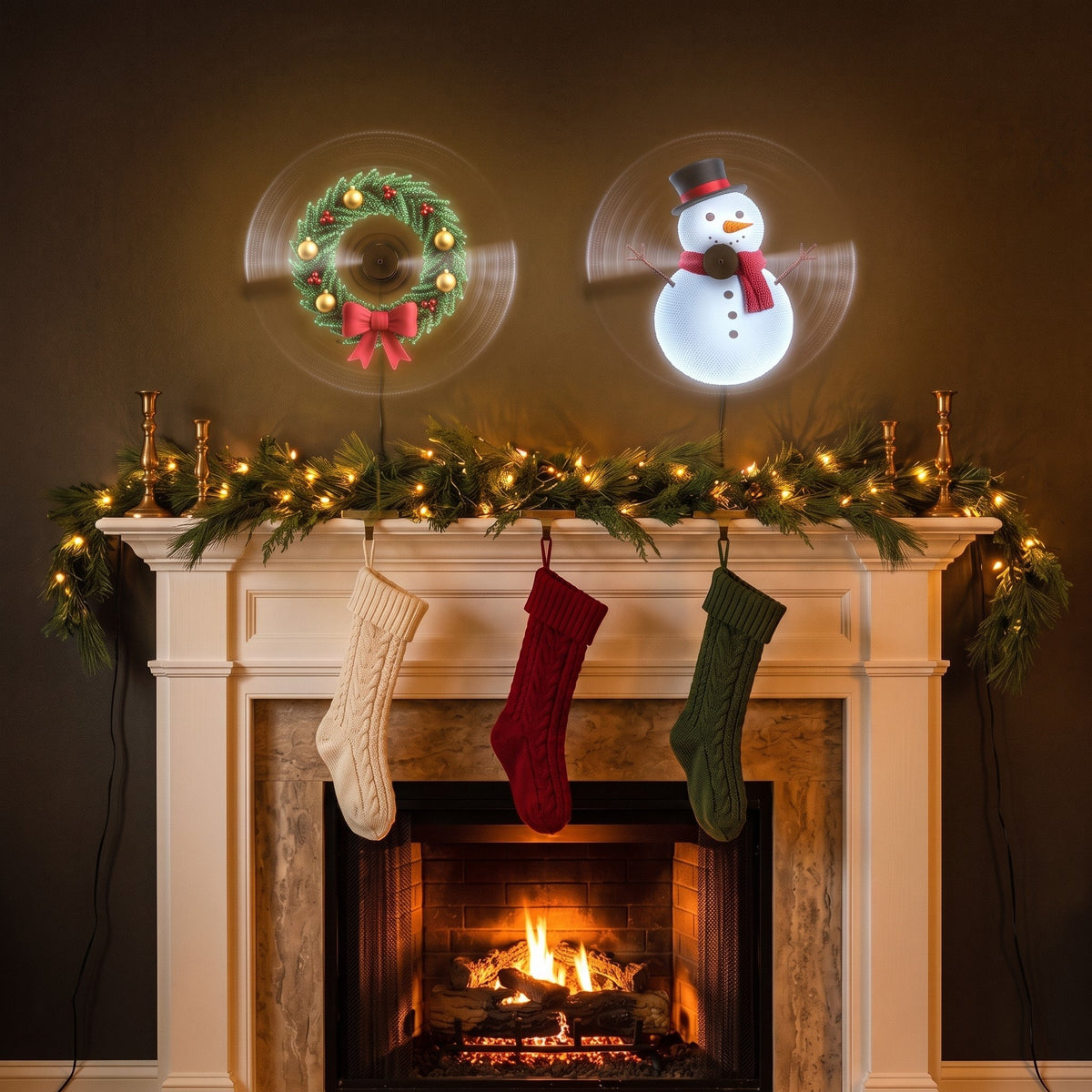 Two hologram fans side by side above a fireplace show a Christmas wreath and a snowman