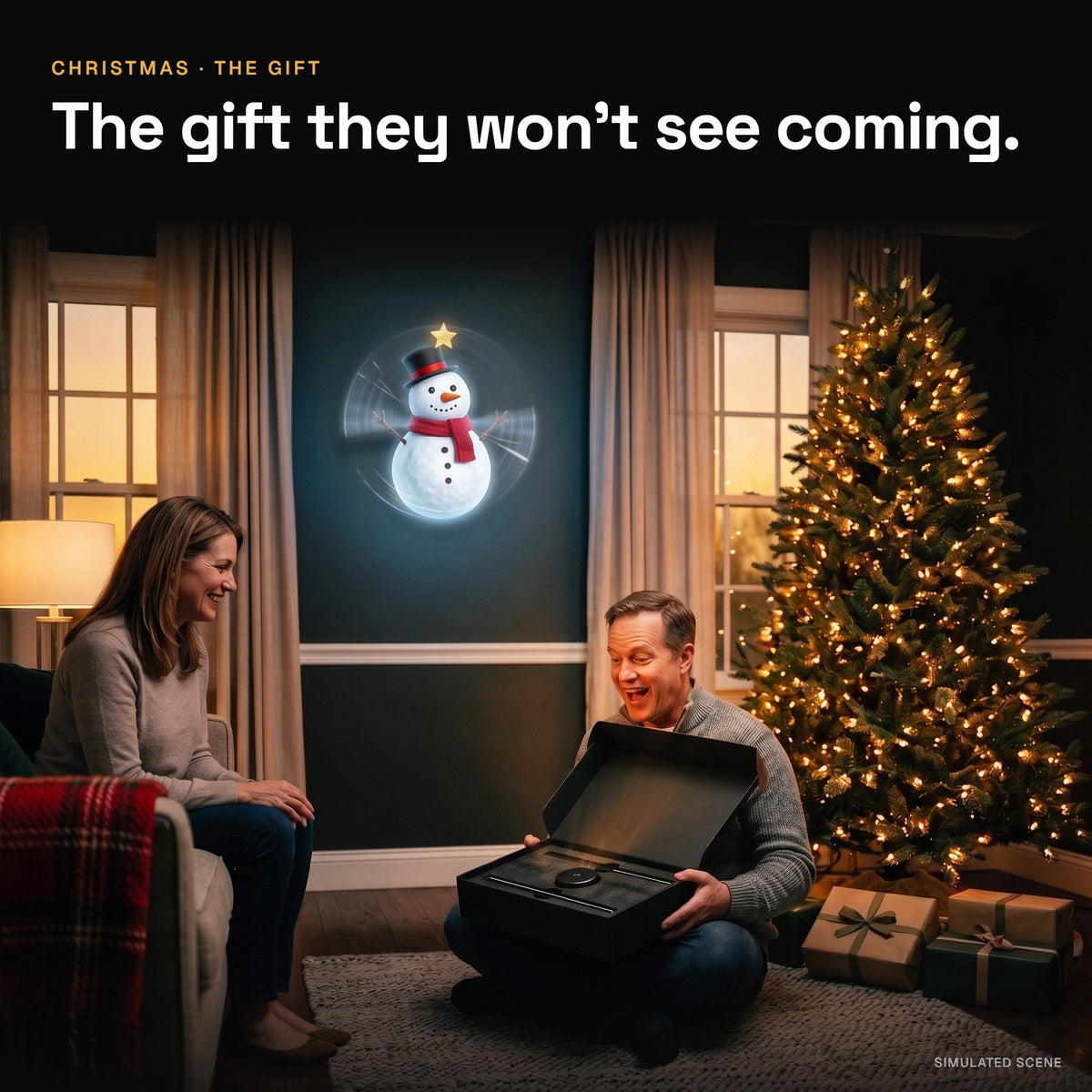 A man opens a black gift box under the Christmas tree while a hologram snowman glows on the wall