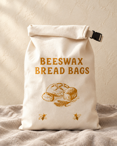 Baker's Script beeswax bread bag with amber lettering, standing on linen