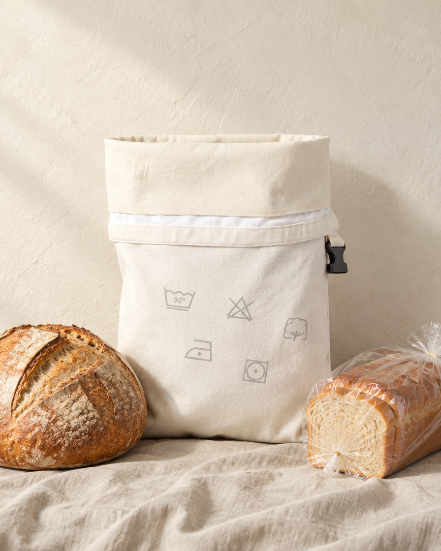 The bread bag beside a sourdough boule and a sliced loaf for scale