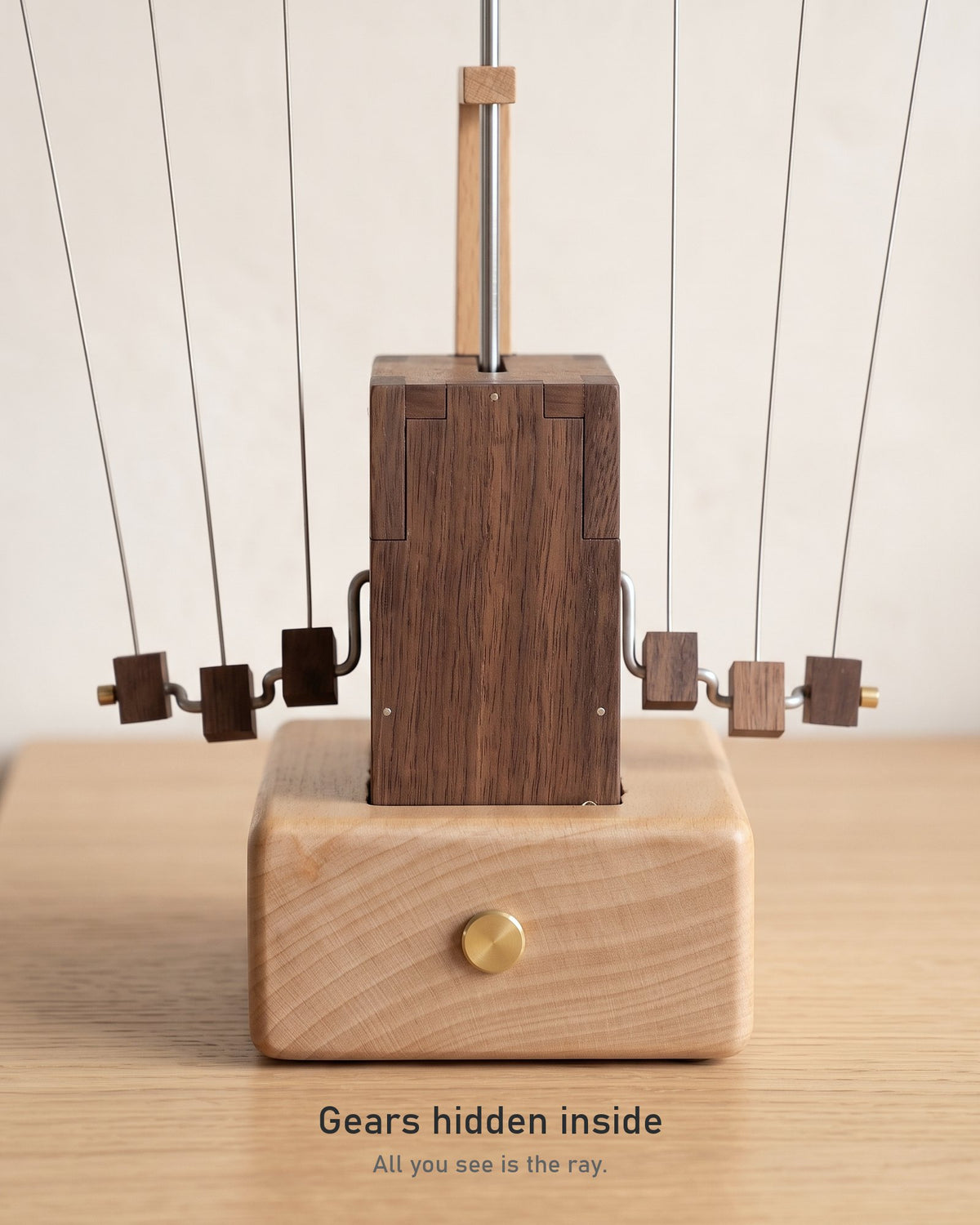 Mechanism close-up: chrome rod, beech guide plate, black walnut box hiding the gears, and six walnut counterweights