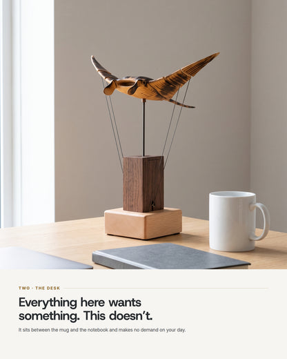 The automaton on a desk between a coffee mug and a notebook