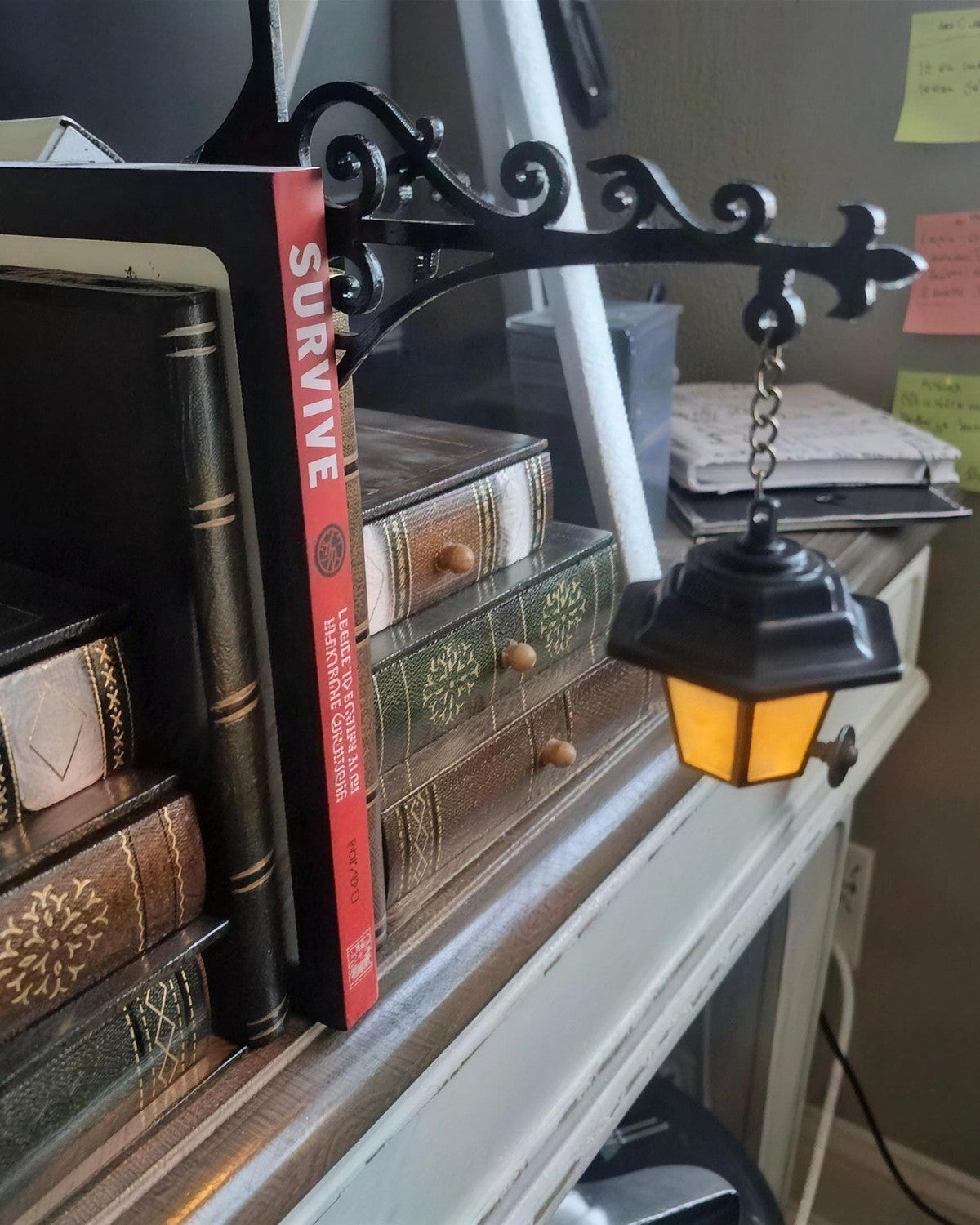 Lantern on a ledge beside leather-bound books