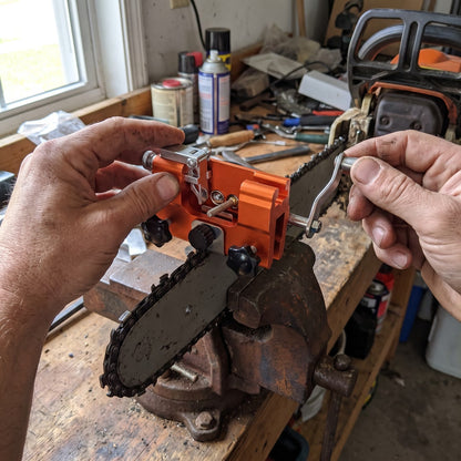 Hands turning the crank of the TrueTooth sharpener on a bar held in a bench vise